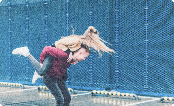 A 90s-style photograph of a boy carrying a girl on his back.