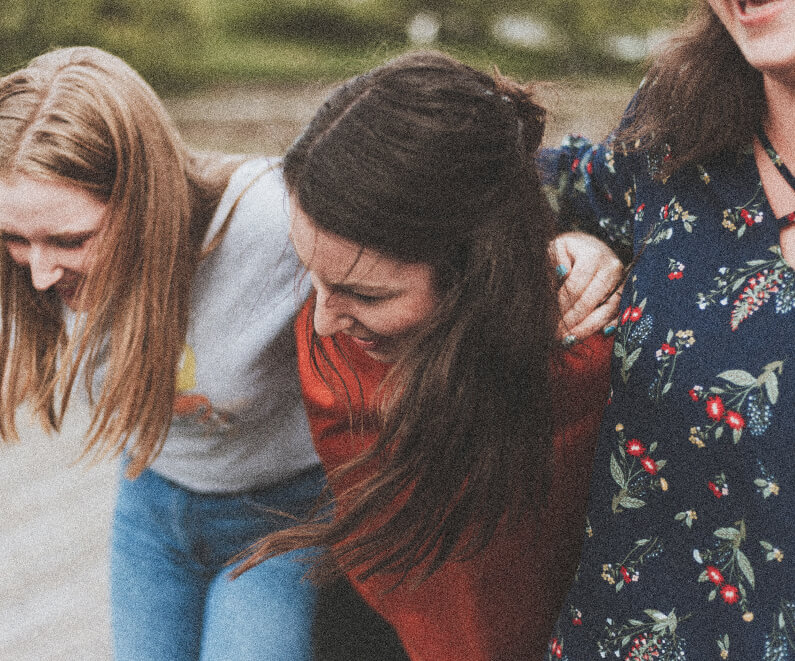 A 90s style photograph of three women interlinking and laughing together as they shift Canada's innovation for a brighter and bolder future.